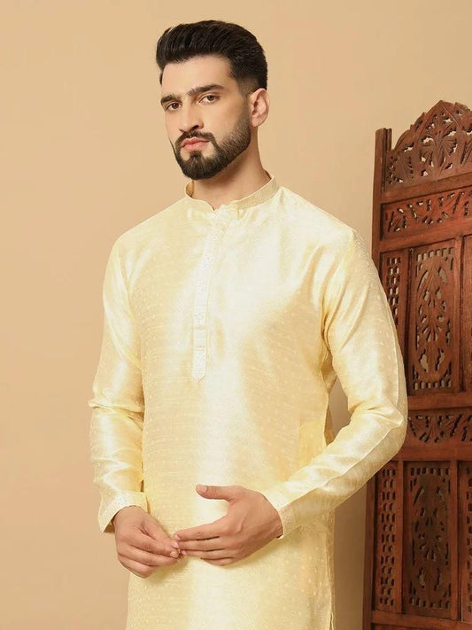 Man wearing a light yellow kurta against a beige background