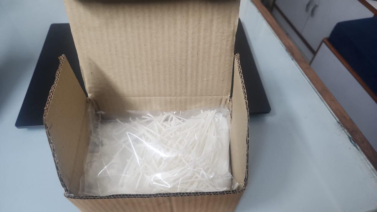Open cardboard box with plastic bags inside on a gray surface