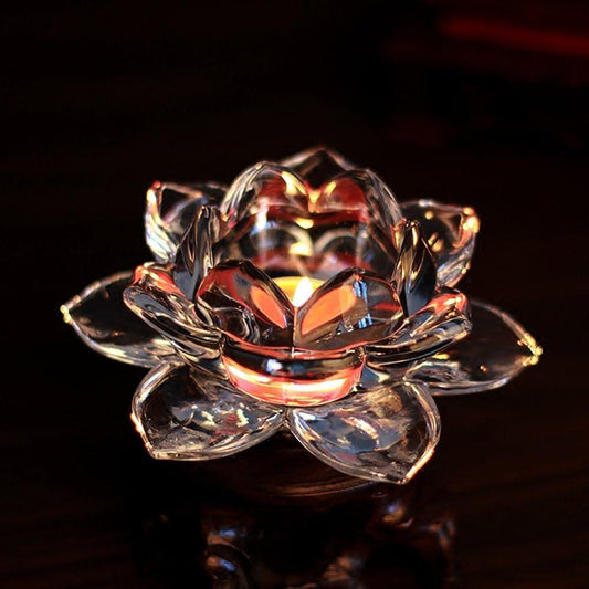 Crystal lotus flower candle holder with a lit candle on a dark background