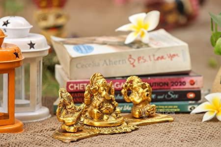 Gold figurines on a stack of books with decorative items in the background