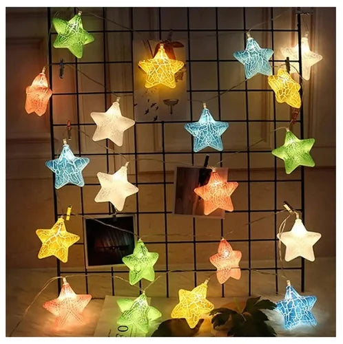 Star-shaped string lights in various colors hanging against a grid wall.