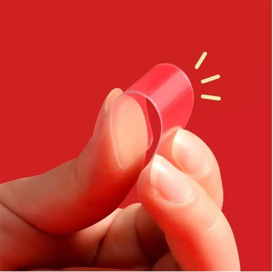 Hand holding a clear plastic object against a red background