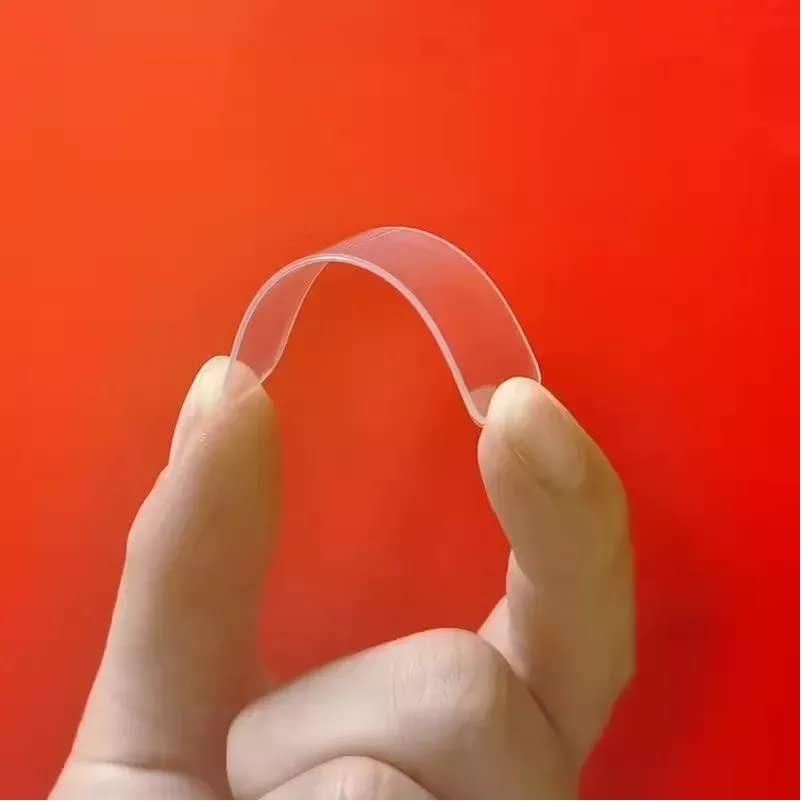 Hand holding a clear plastic strip against a red background