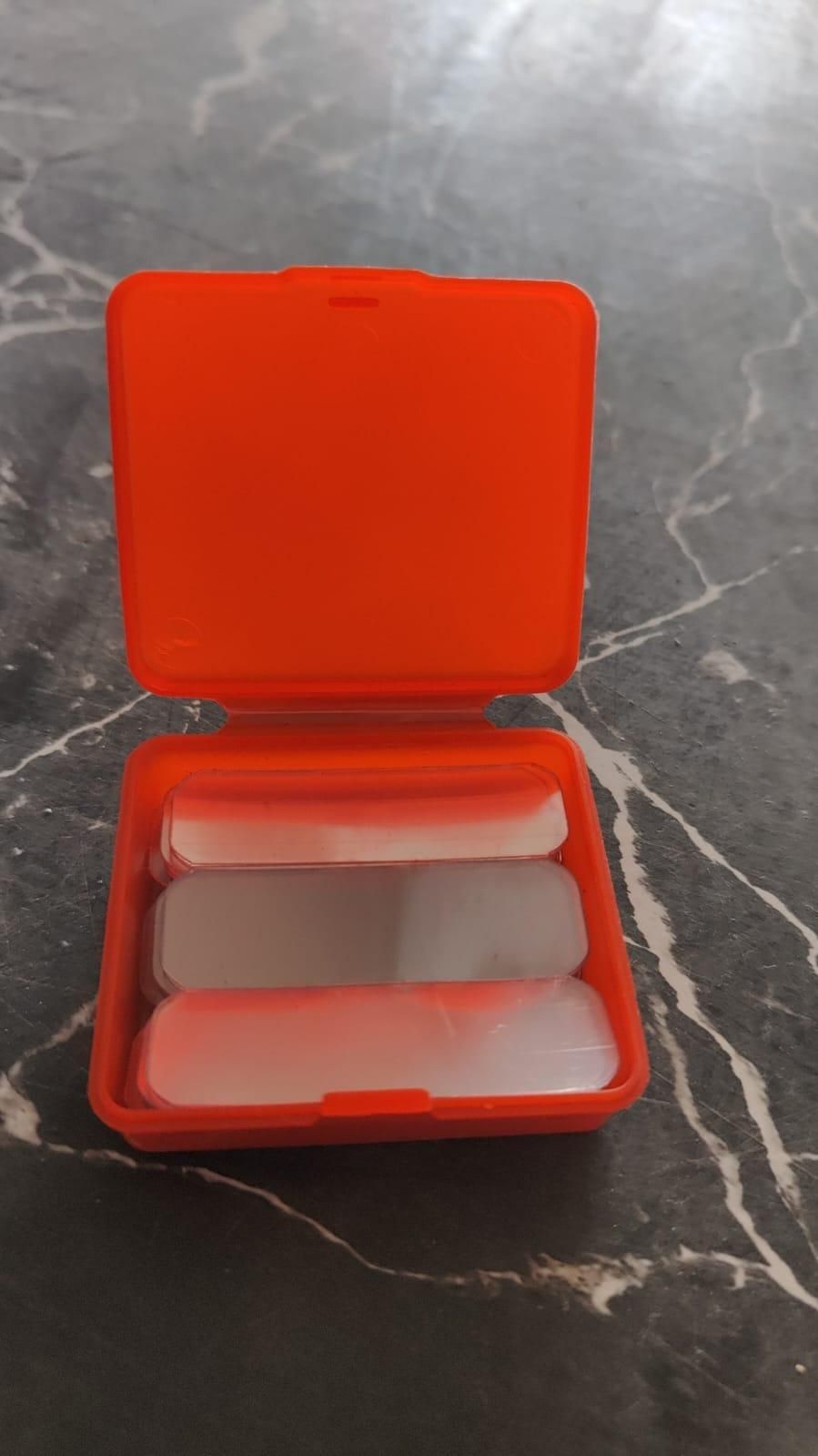 Red container with white objects on a gray marble surface