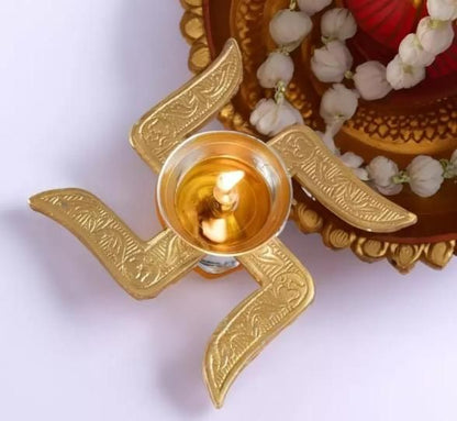 Decorative gold oil lamp with a lit candle on a white background