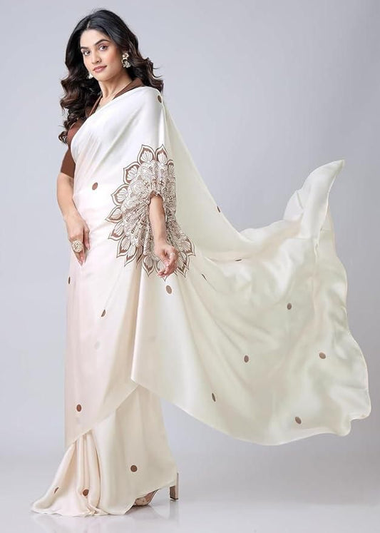 Woman wearing a white saree with intricate designs on a plain background