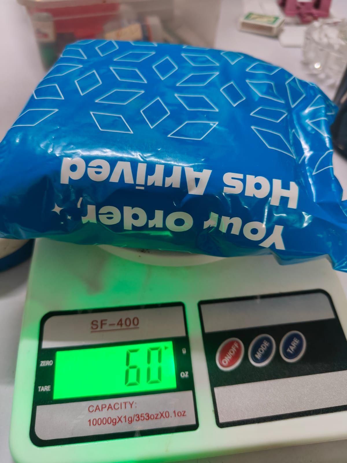 Blue package with 'Your Order Has Arrived' text on a digital scale displaying weight.