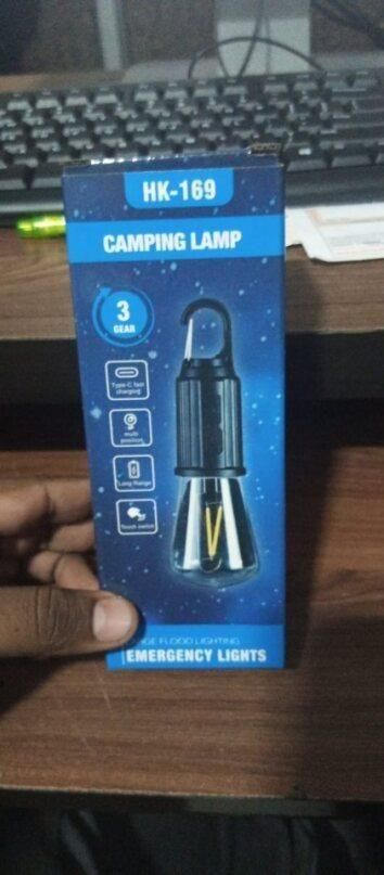 Camping lamp packaging with 'HK-169' on a wooden surface