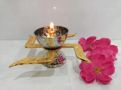 Decorative oil lamp with a lit candle and pink flowers on a white background