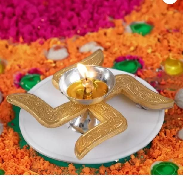 Decorative oil lamp with a lit candle on a colorful floral background