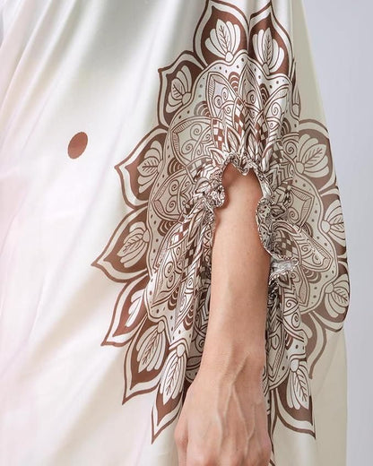 Close-up of a hand wearing a bracelet with intricate brown and white pattern on a light fabric background