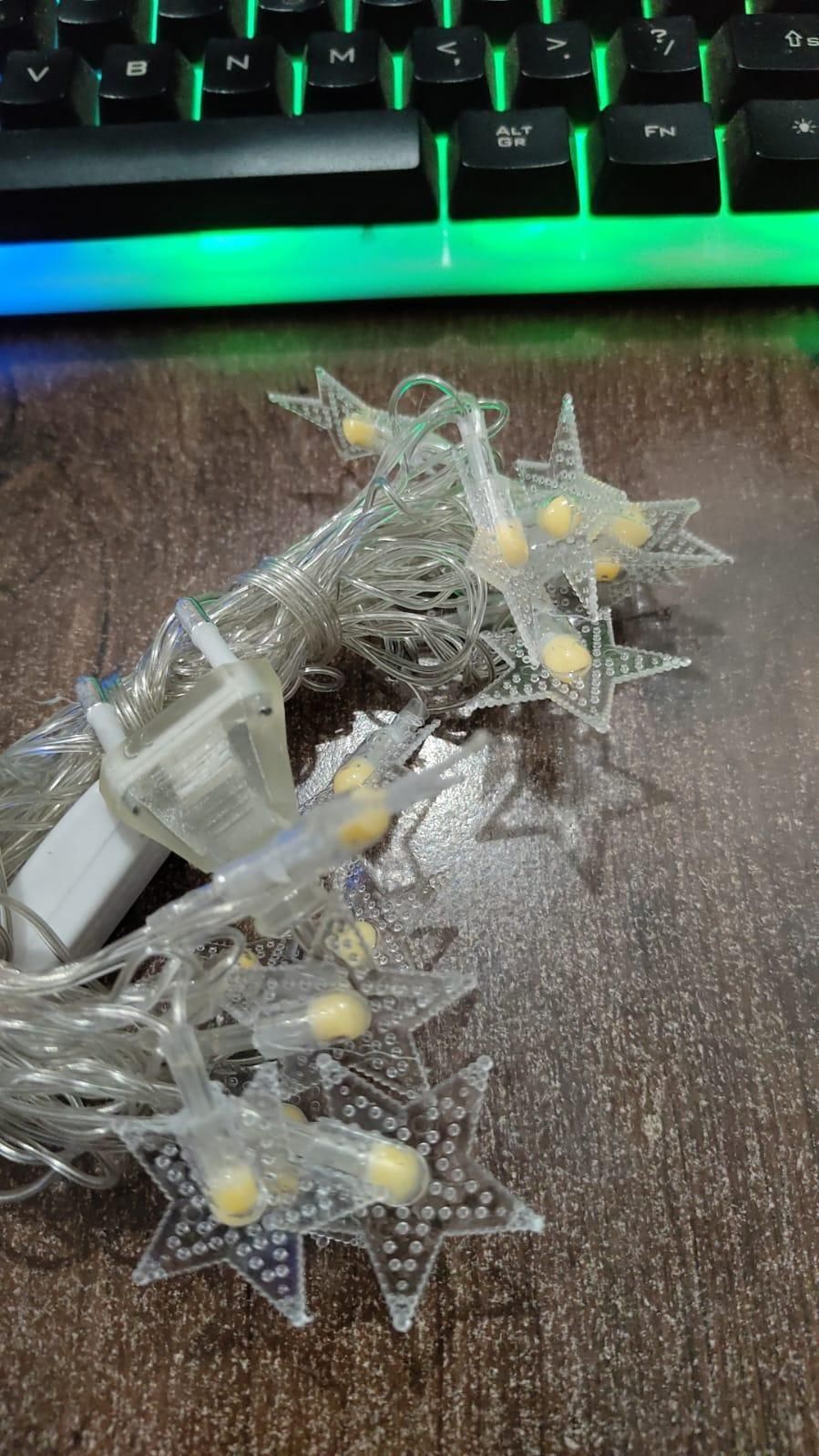 Star-shaped string lights on a textured surface with a keyboard in the background