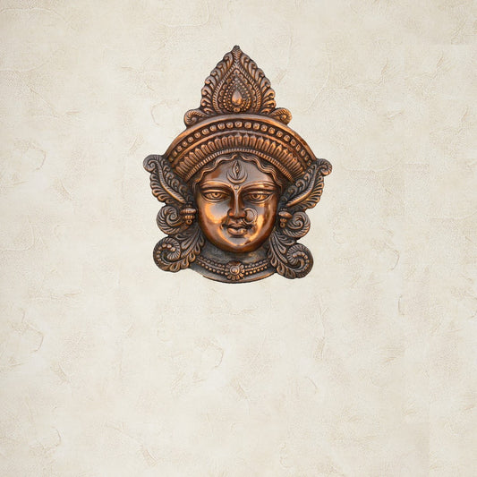 Decorative wall mask with intricate design on a beige wall