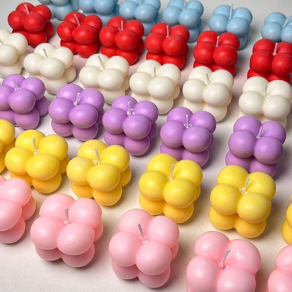 Colorful bubble-shaped candles arranged in rows on a light background