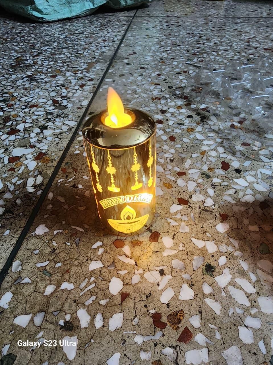 Lit candle in a decorative holder on a textured floor