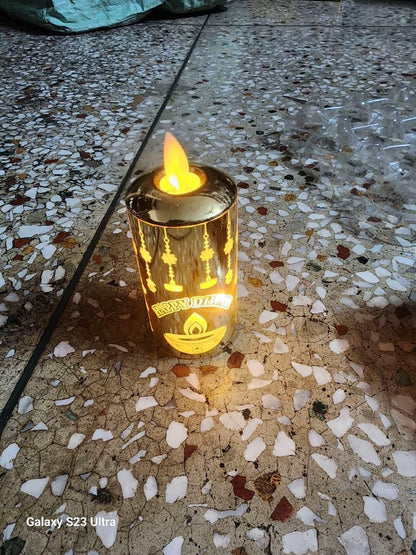 Lit candle in a decorative holder on a textured floor