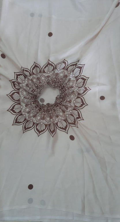 White fabric with a brown mandala design and small brown dots on a white background
