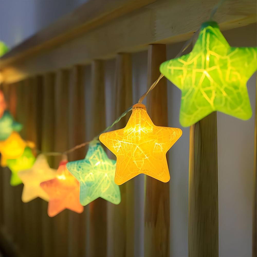 String of colorful star-shaped lights against a wooden fence background