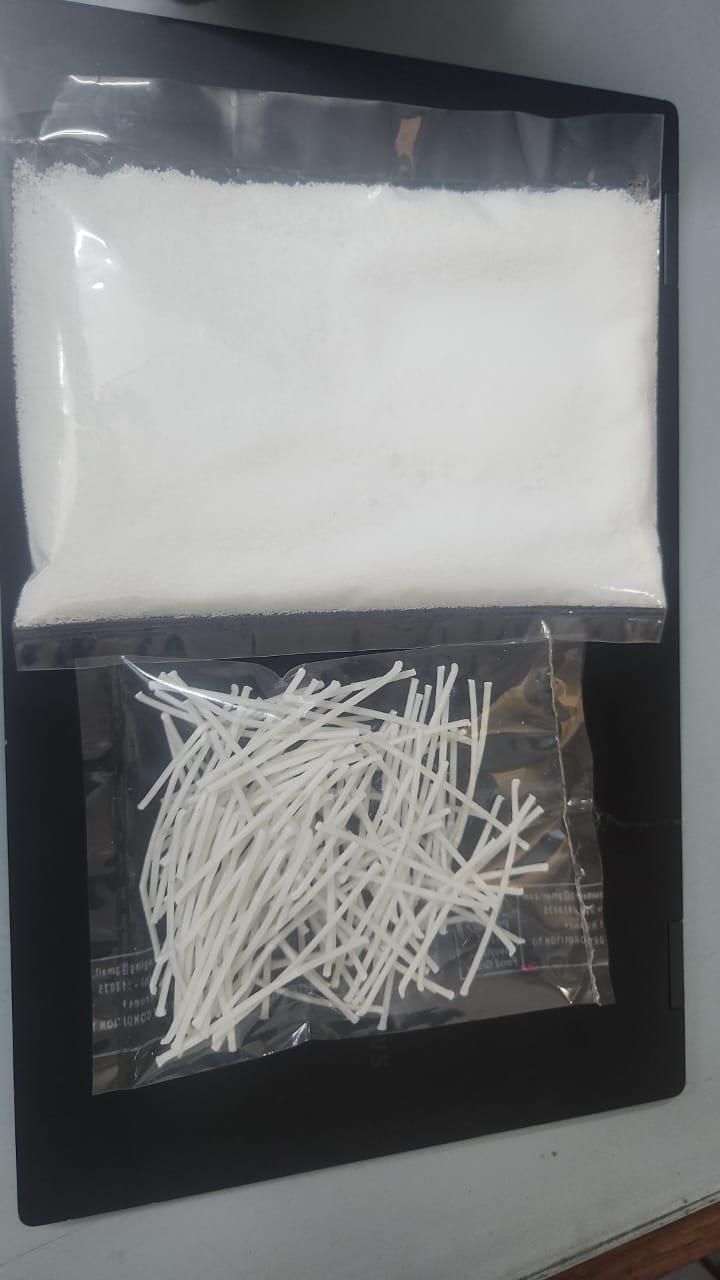 Two clear plastic bags containing white cotton swabs and cotton balls on a dark surface.