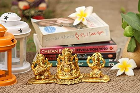 Gold figurines on books with decorative items in the background