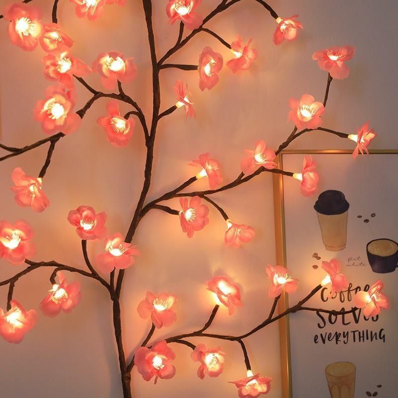 Decorative LED cherry blossom tree with pink flowers and warm light on a plain background.