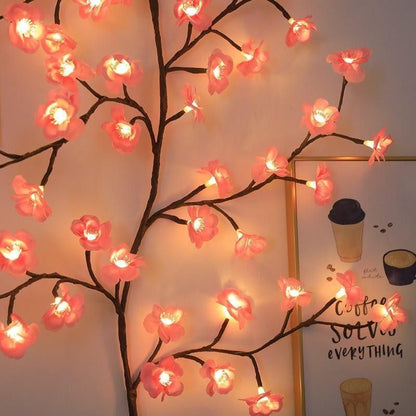 Decorative LED cherry blossom tree with pink flowers and warm light on a plain background.