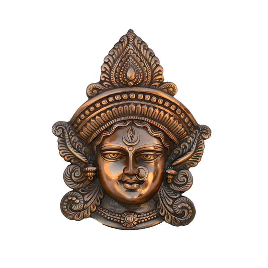 Decorative bronze mask with intricate designs on a white background