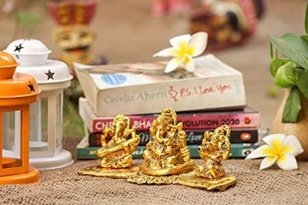 Gold figurines on a table with books and decorative items in the background