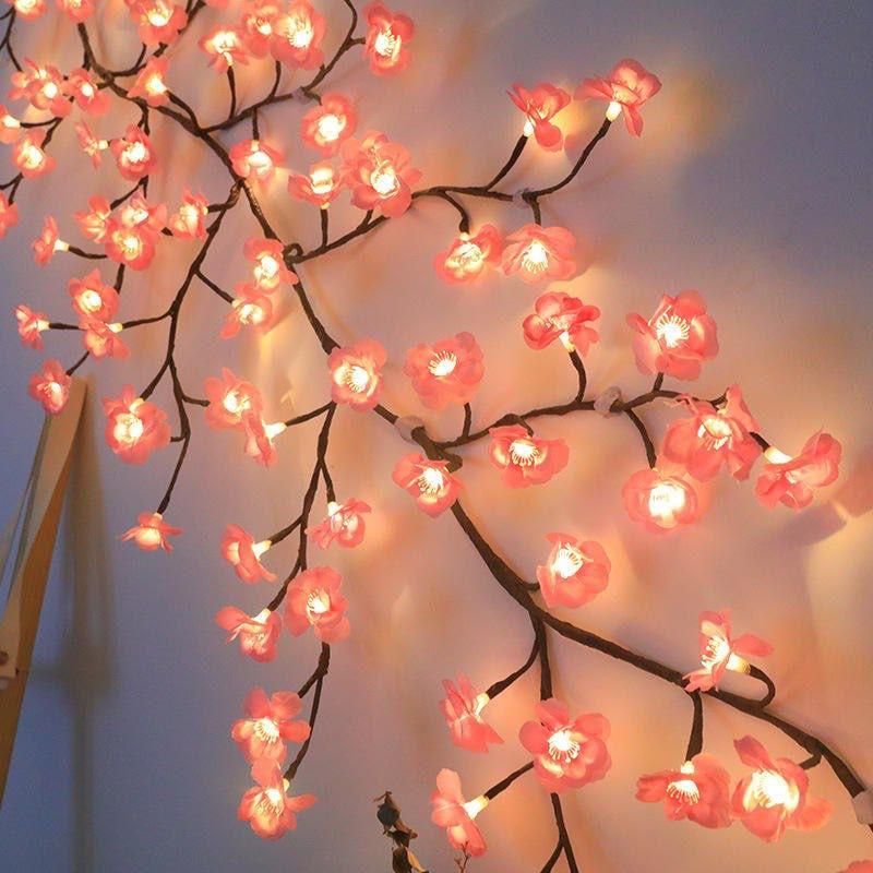 Decorative string lights shaped like cherry blossom branches with pink flowers and warm white bulbs.