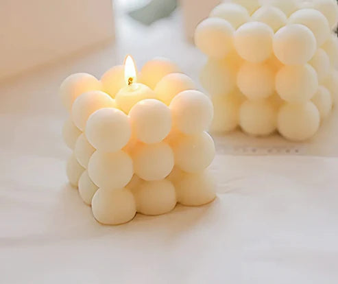 Candle with bubble-like design on a white surface